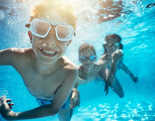 3 crianças nadando em uma piscina