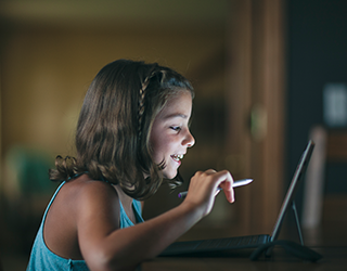 Uma criança sorrindo usando um tablet