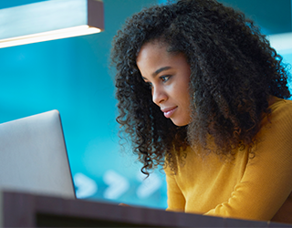 Uma mulher olhando concentrada para um notebook